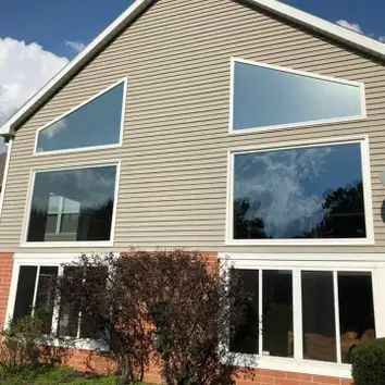 A large house with a lot of windows on the side of it.