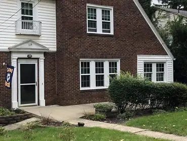 A large brick house with a white trim and a lot of windows.