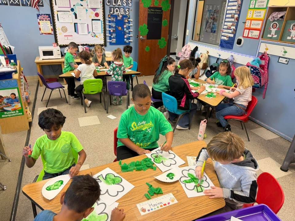 Children doing arts and crafts at tables in a colorful classroom