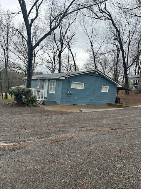 A small house with a flag on the side of it is surrounded by trees.