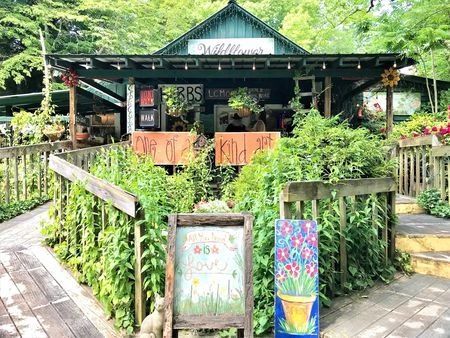 There is a sign in front of a building that says `` herbs ''.