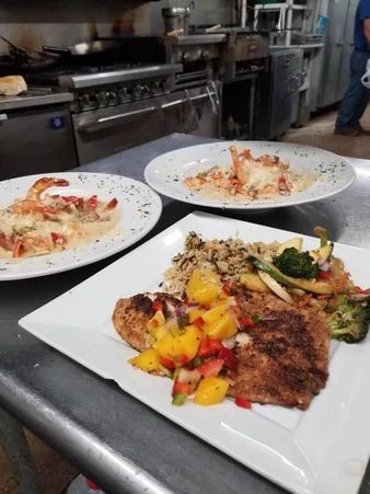 Three plates of food are sitting on a counter in a kitchen.