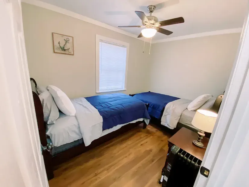 A bedroom with two beds and a ceiling fan