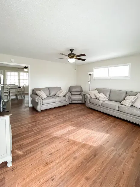 A living room with two couches and a ceiling fan.