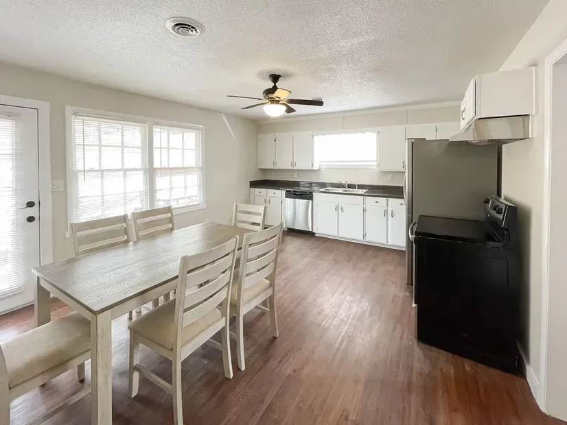 A kitchen with a table and chairs and a ceiling fan