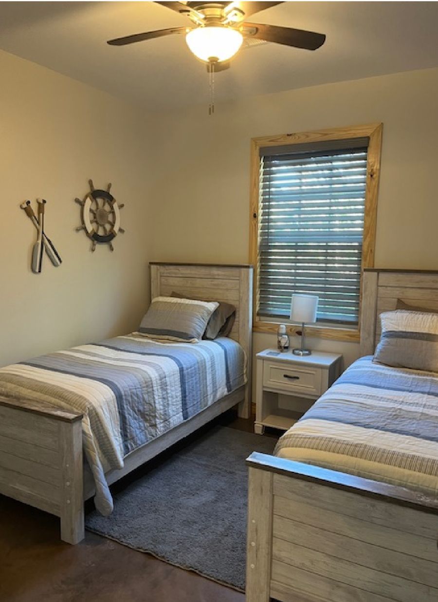 A bedroom with two twin beds and a ceiling fan.