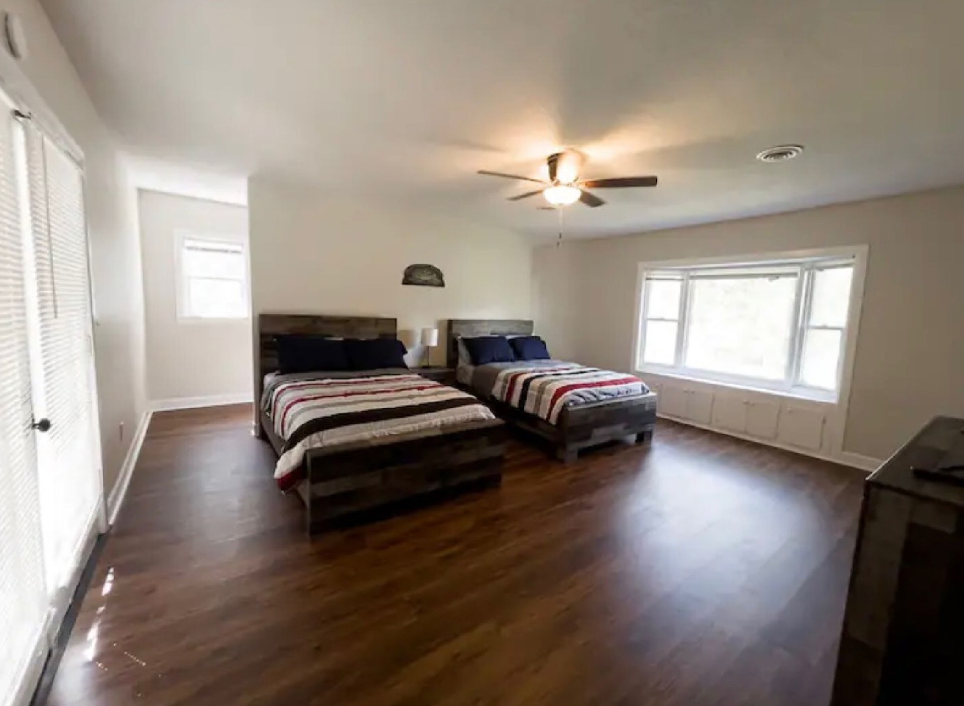 A bedroom with two beds and a ceiling fan.