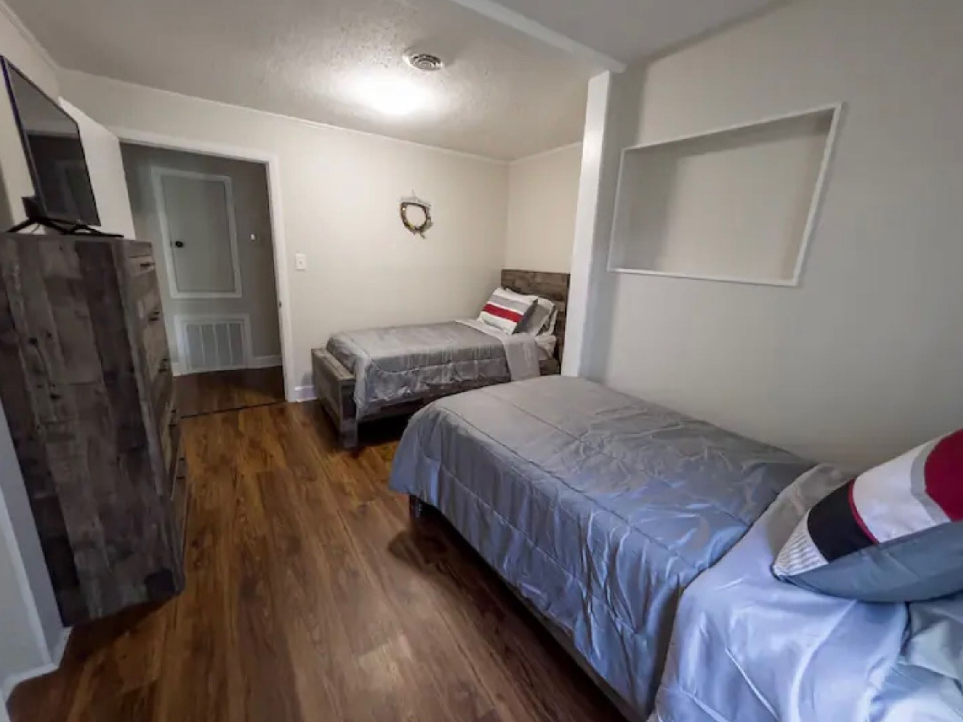 A bedroom with two beds and a flat screen tv.