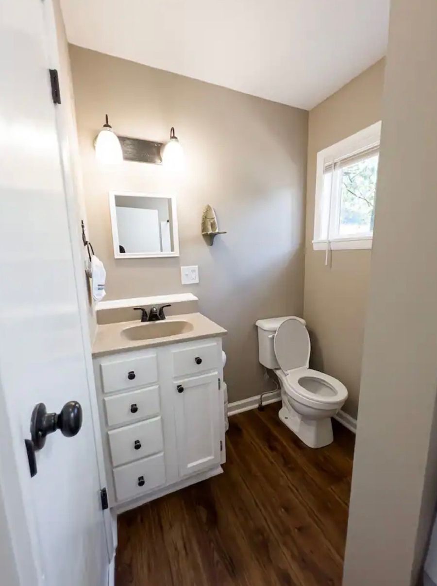 A bathroom with a sink, toilet, and mirror.