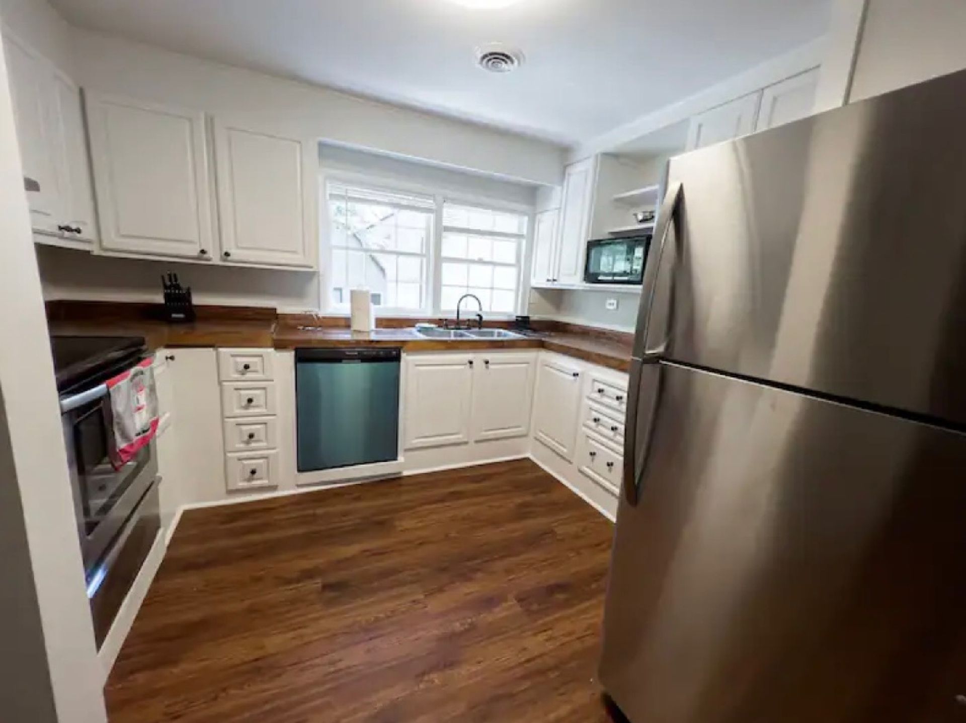 A kitchen with stainless steel appliances and white cabinets.