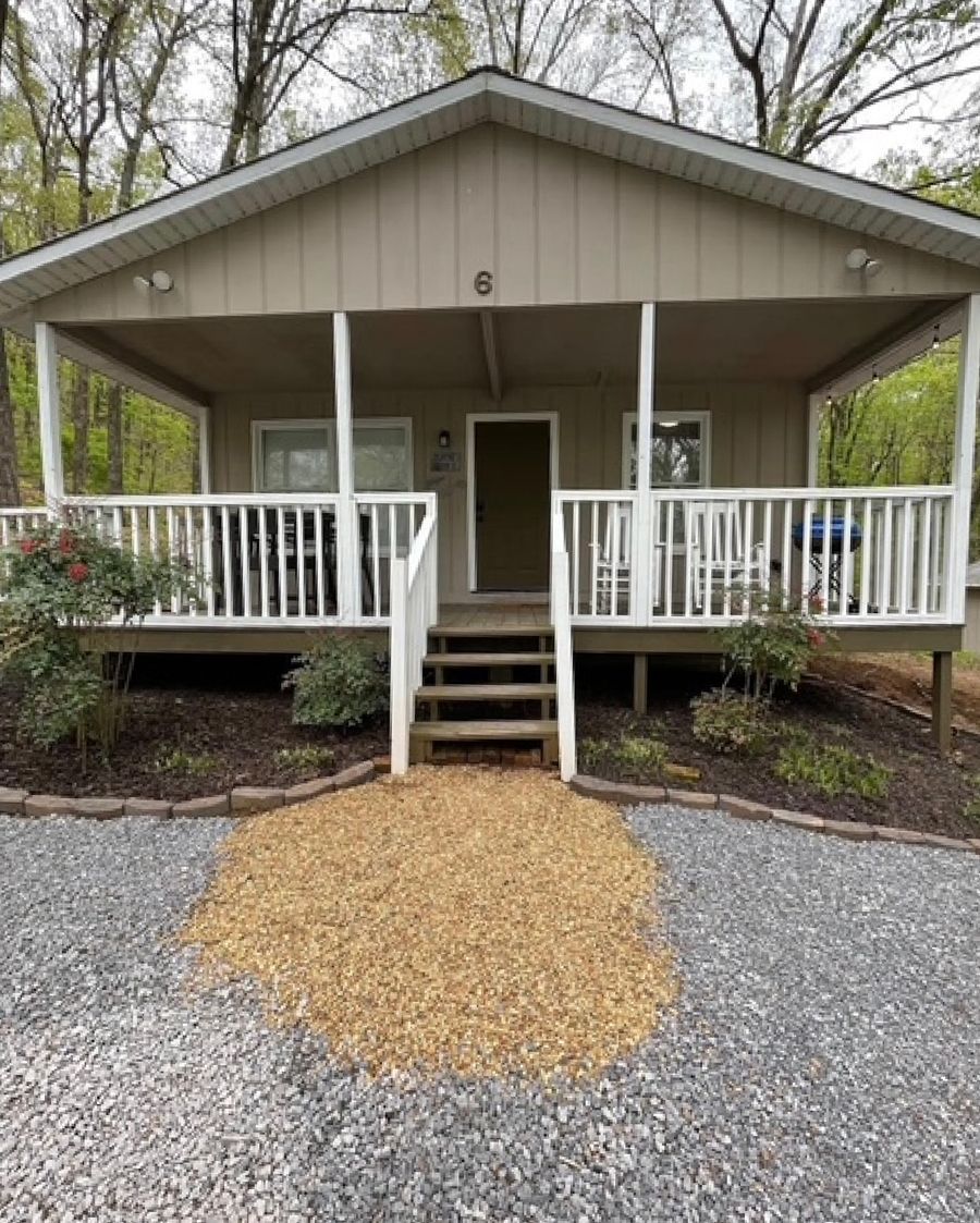A small house with a porch and stairs leading up to it.