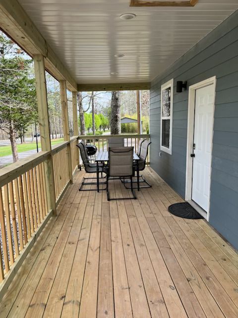 A porch with a table and chairs on it