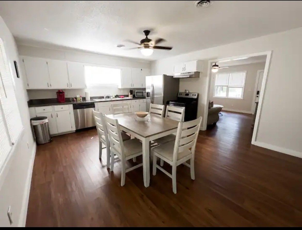 A kitchen with a table and chairs and a ceiling fan