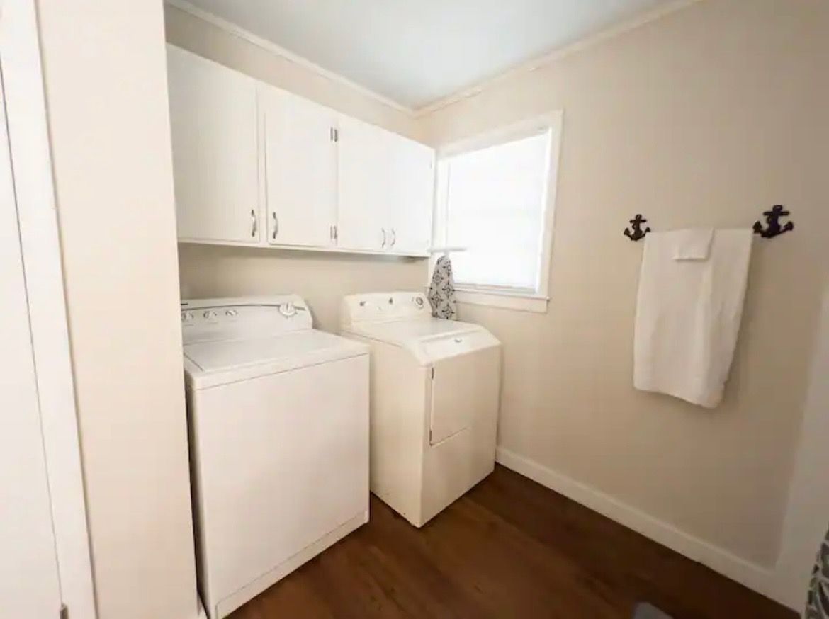 A laundry room with a washer and dryer and a window.