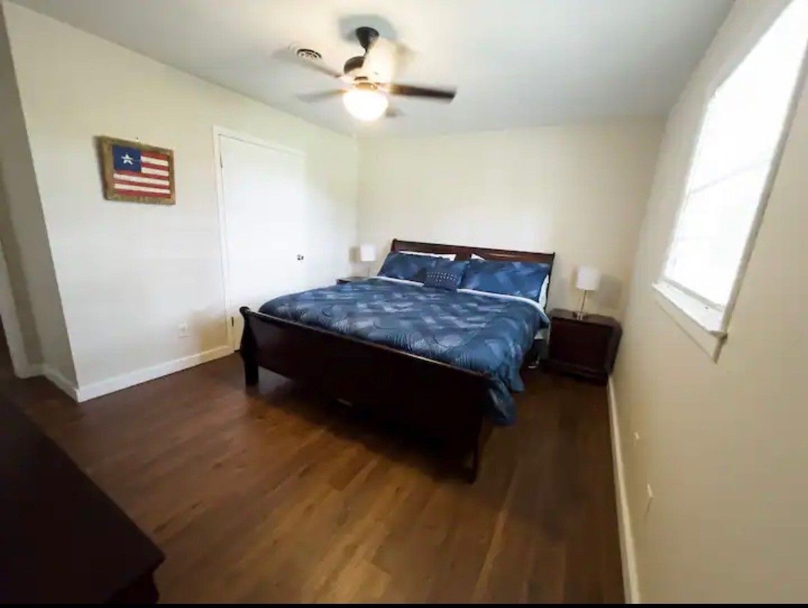 A bedroom with a bed and a ceiling fan