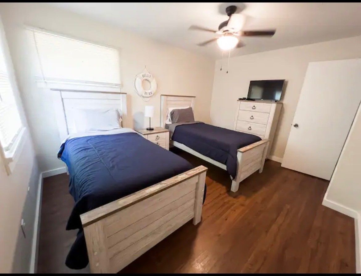 A bedroom with two twin beds and a ceiling fan.