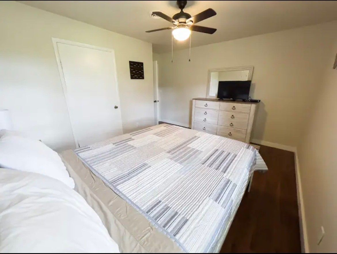A bedroom with a bed and a ceiling fan