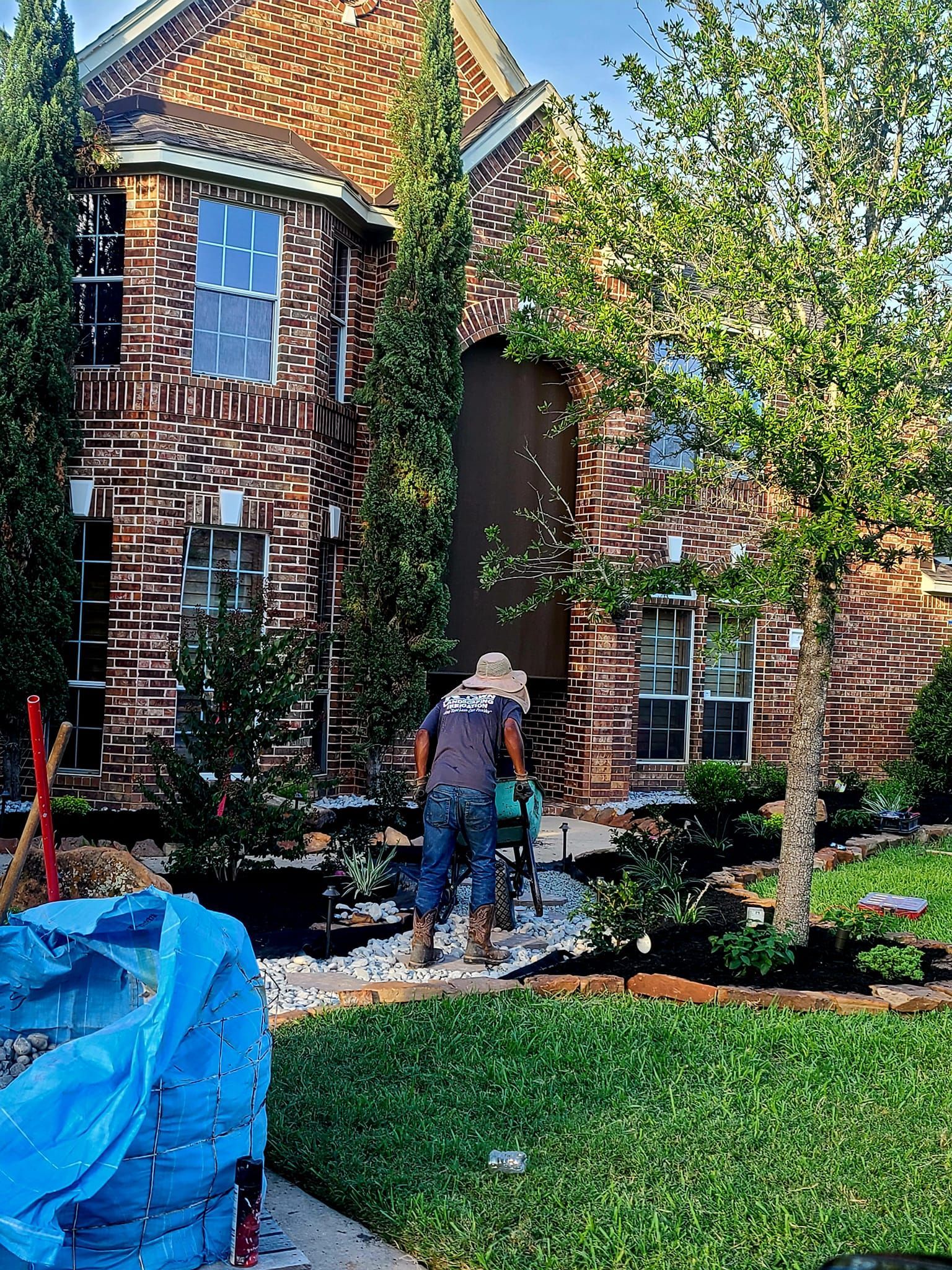 A man is standing in front of a brick house