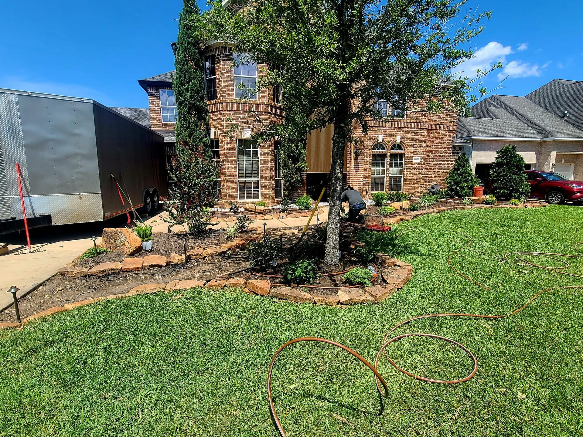 A man is working on a lawn in front of a house