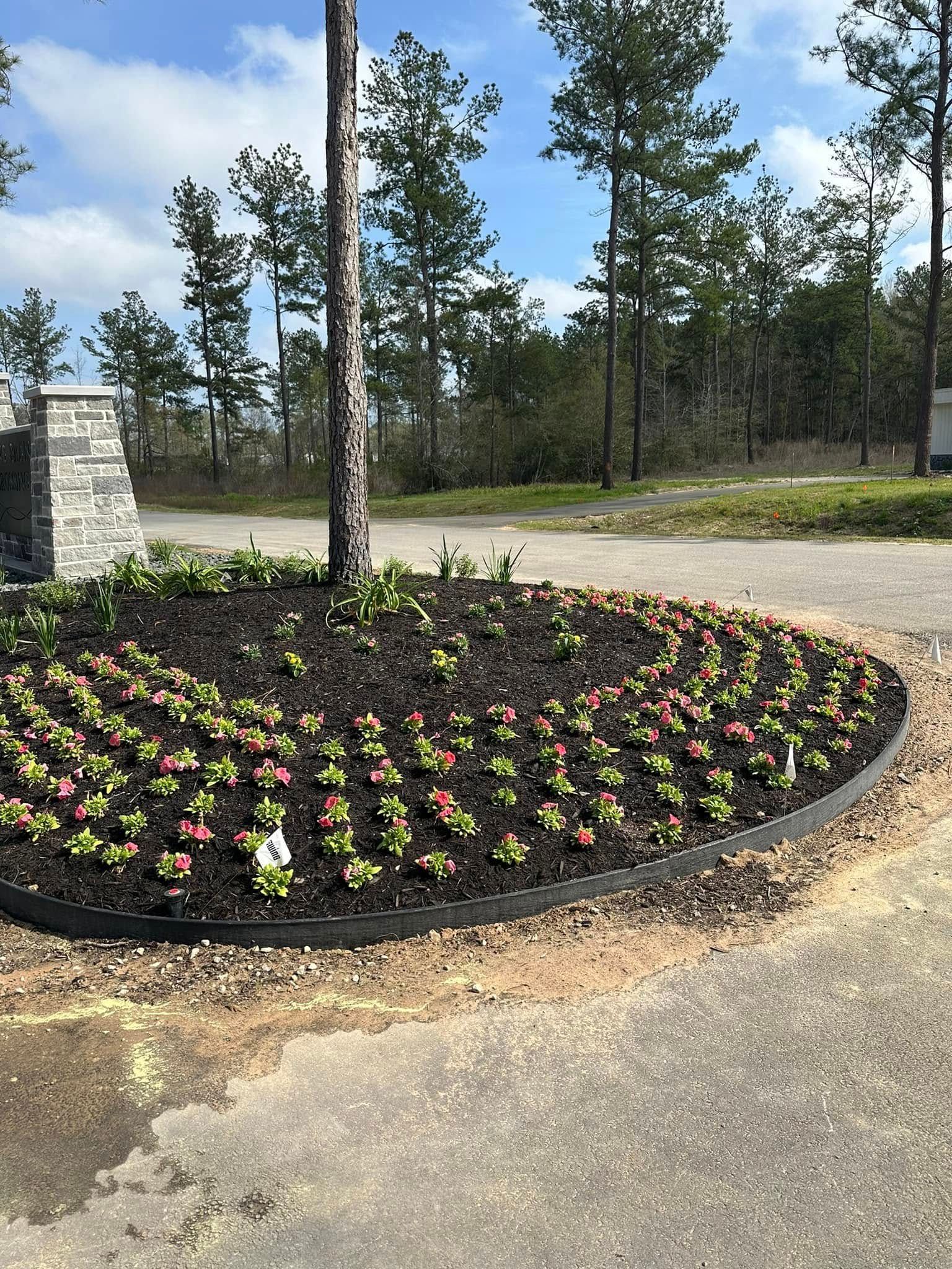 A circular garden with flowers and trees in the background