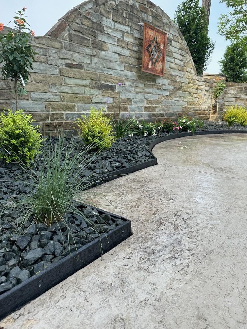A concrete walkway with a brick wall in the background