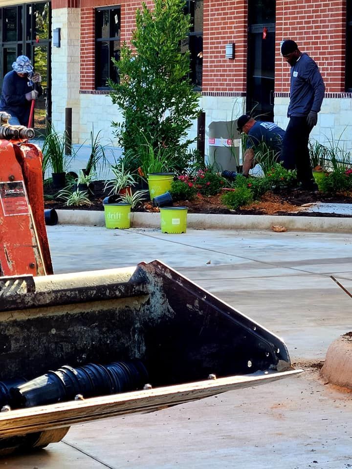 A group of men are working on a sidewalk in front of a brick building