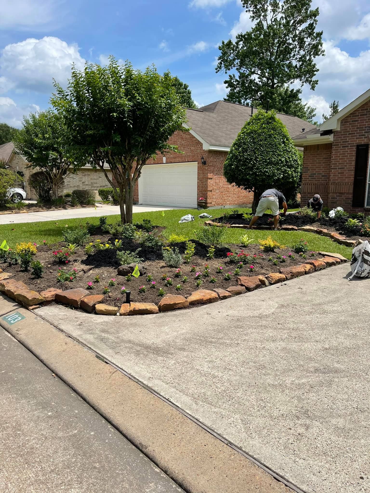 A man is working on a garden in front of a house