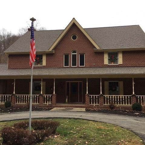 A large brick house with an american flag in front of it