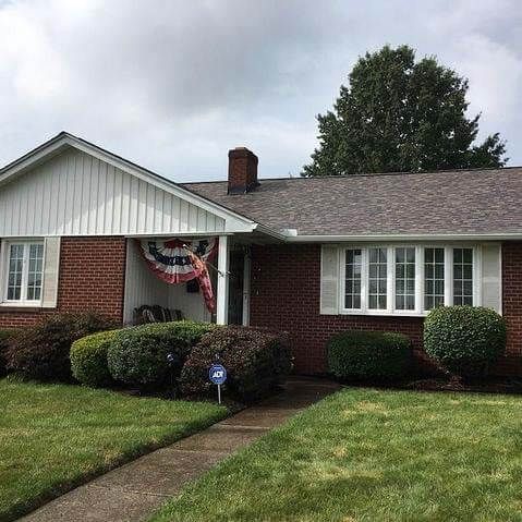 A brick house with a flag on the front porch.