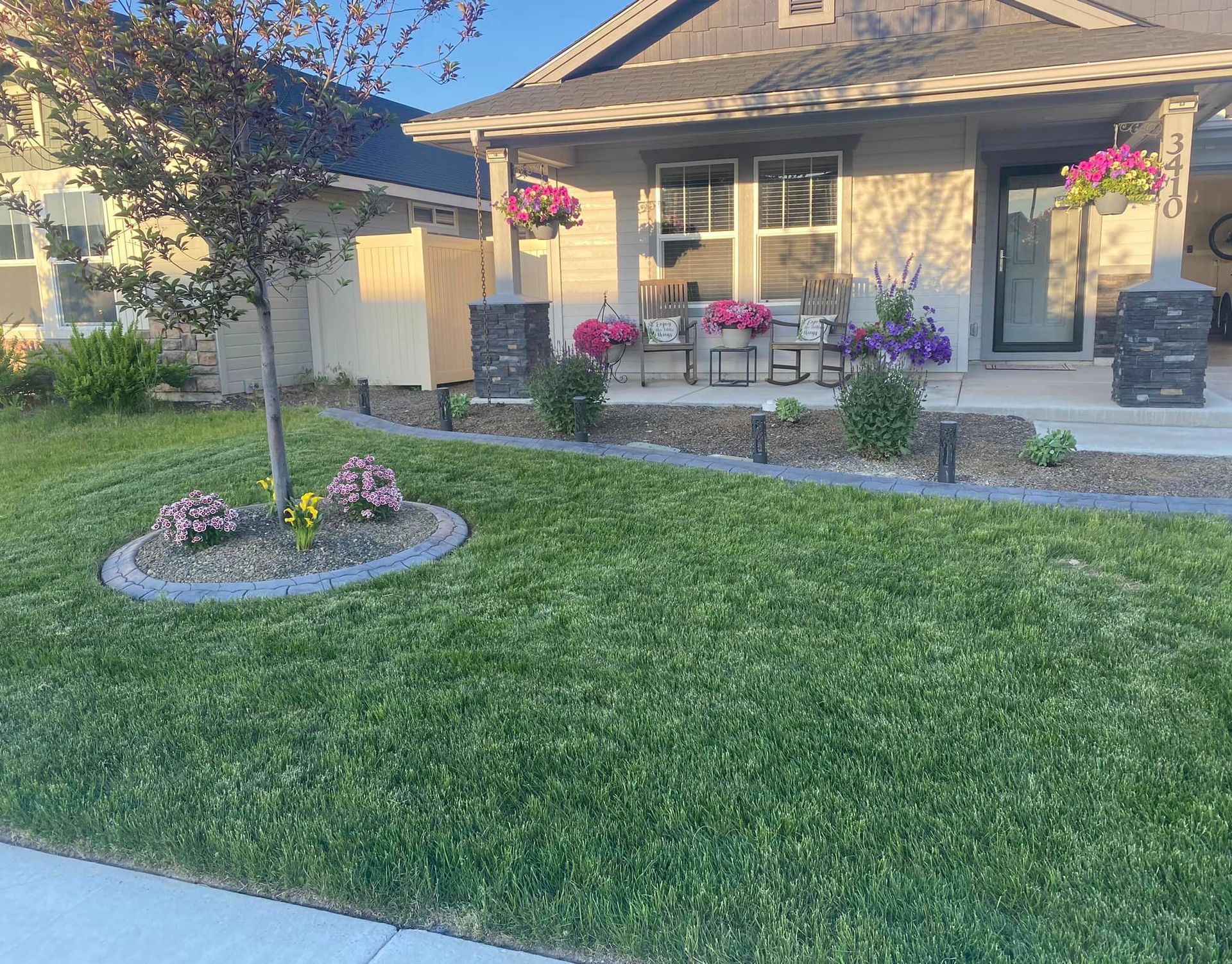 a house with a lush green lawn and flowers in front of it