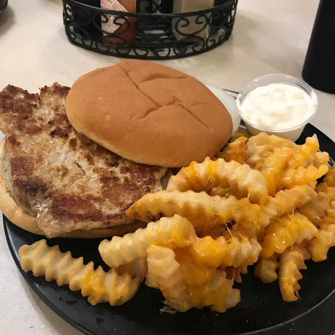 Grilled sandwich with crinkle-cut fries and a small cup of dipping sauce on a plate