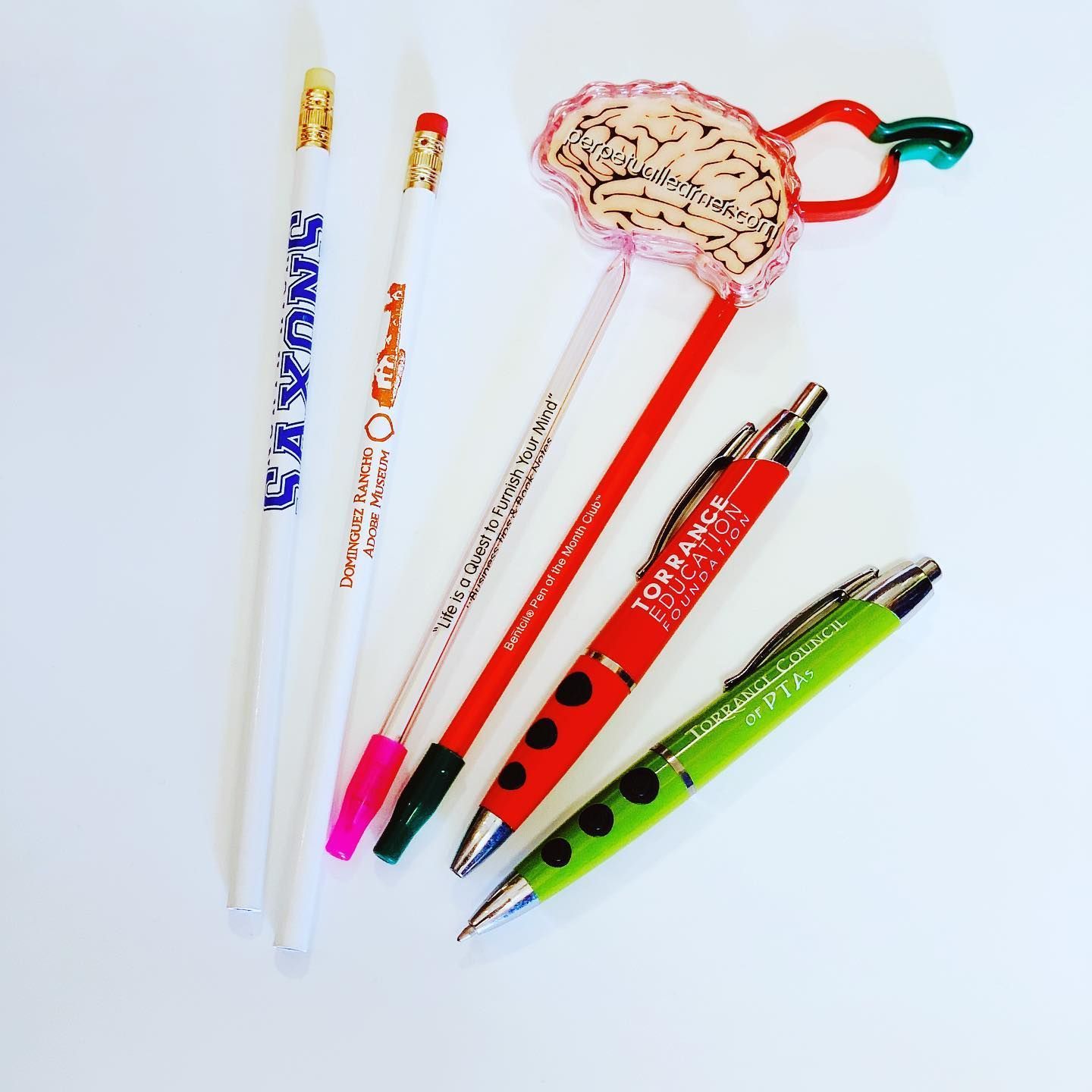 Six pens: pencils and ballpoints, red, green, and white, some with decorations.