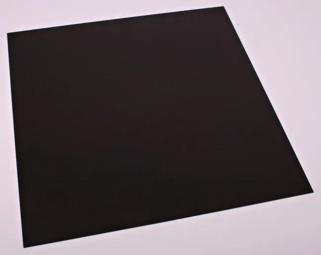 Dark rectangular sheet on a light surface, viewed at an angle.