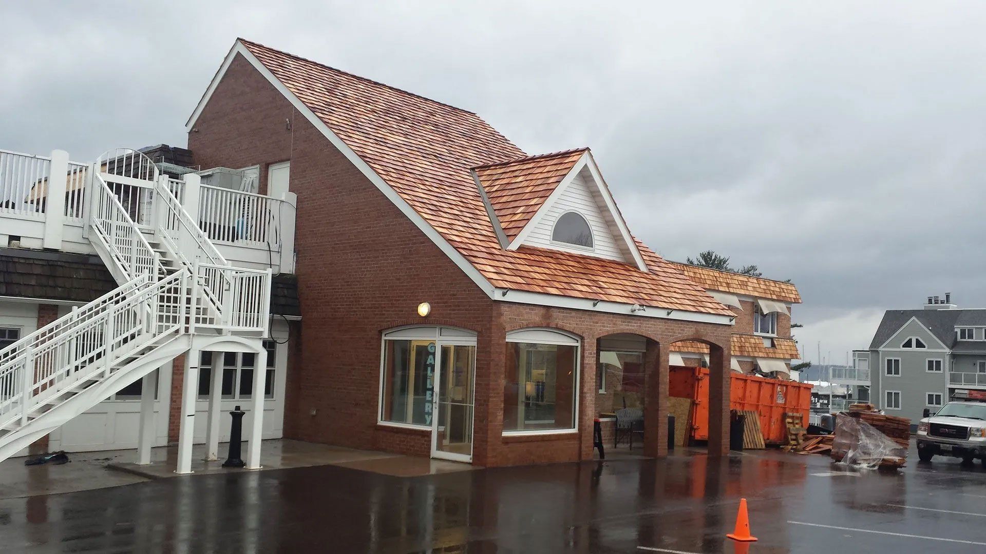 Damaged building with roof torn off, standing in floodwater on a rainy street