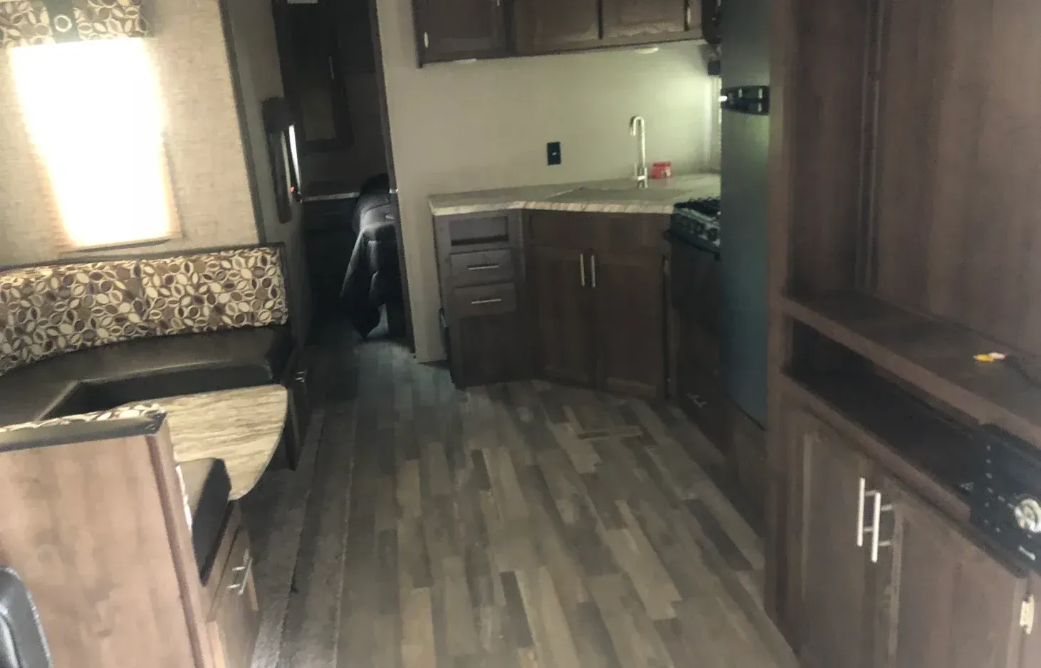 The inside of a trailer with a couch and a kitchen.