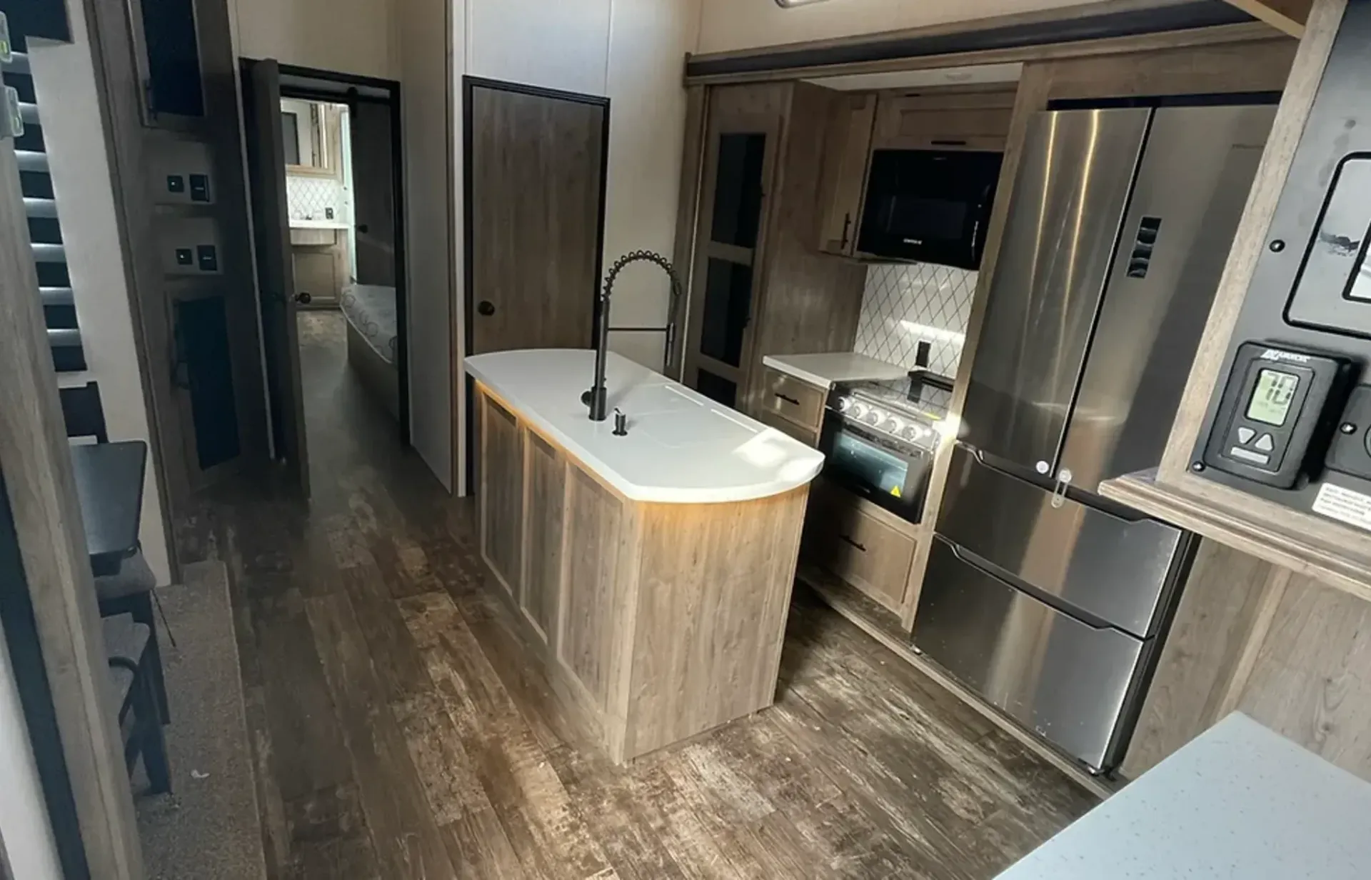 A kitchen in a trailer with stainless steel appliances and a large island.