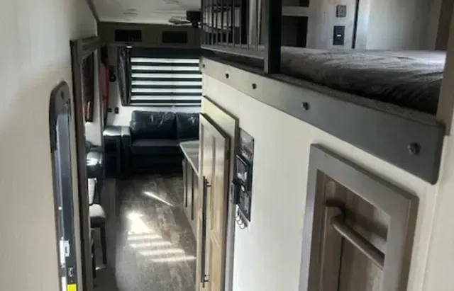 A hallway in a rv with bunk beds and a couch.