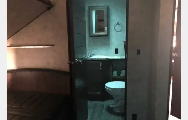 A bathroom with a toilet , sink and mirror