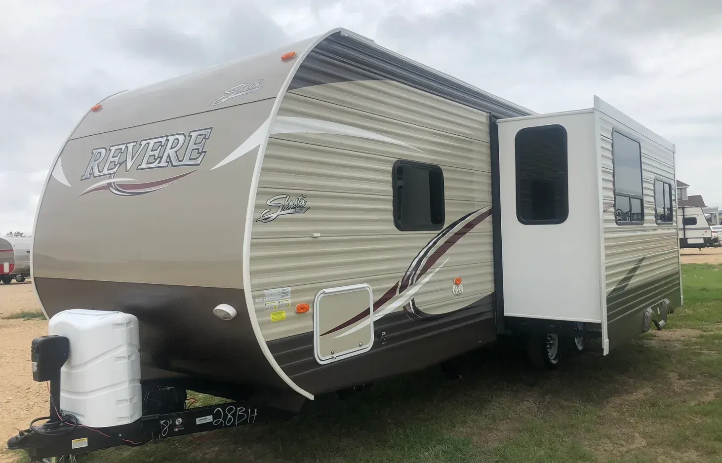 A travel trailer is parked in a grassy field.