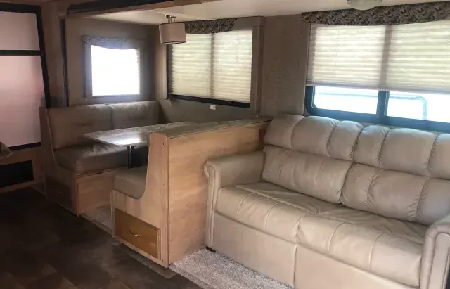 A living room in a rv with a couch and a table.