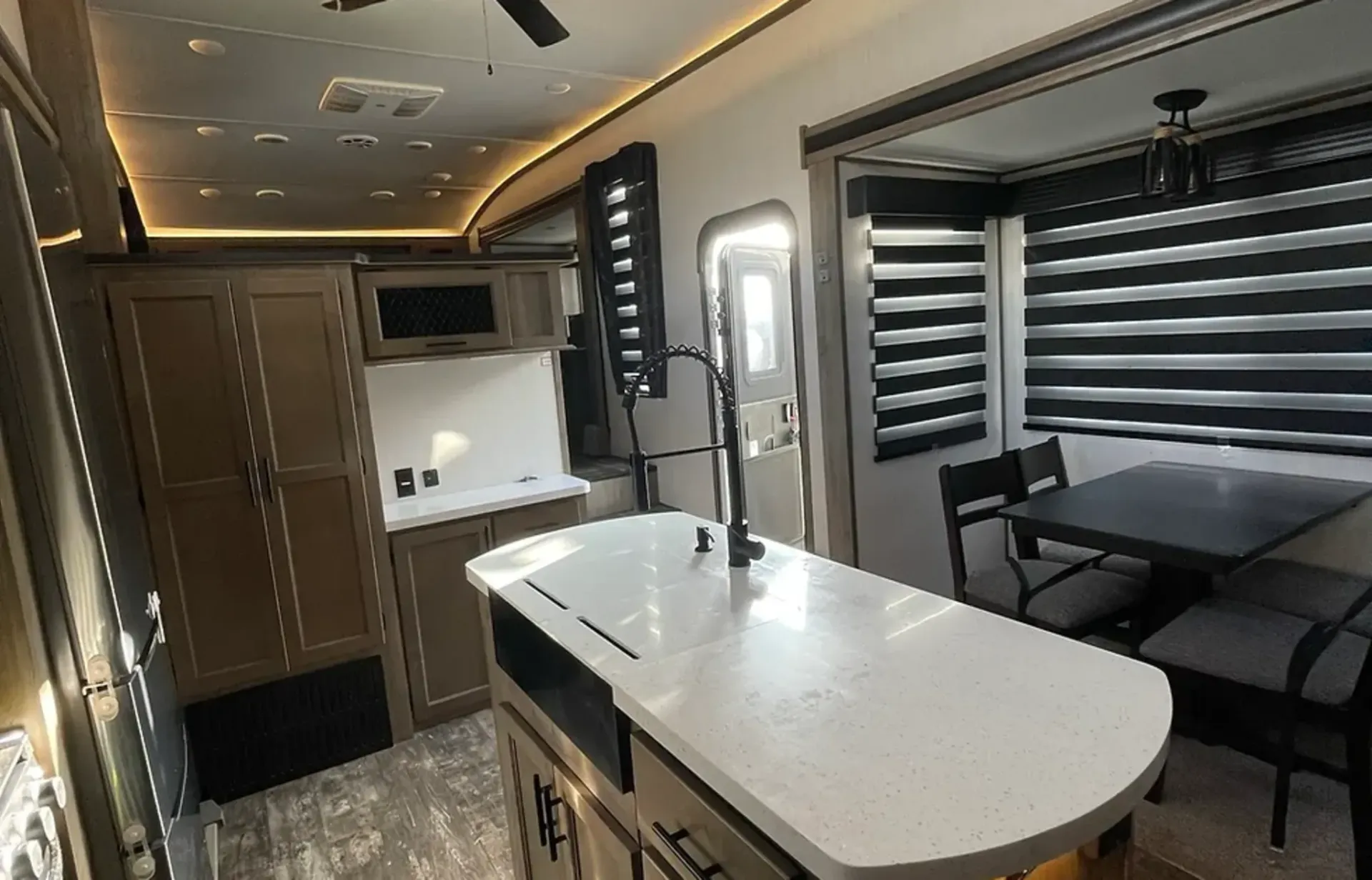 A kitchen in a rv with a large island and a table.