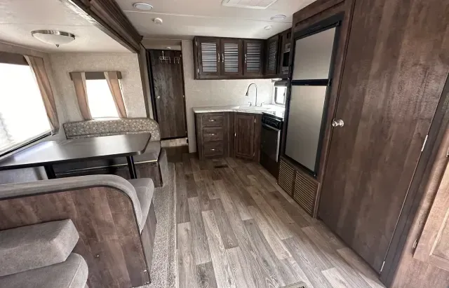A living room in a trailer with a table and chairs.