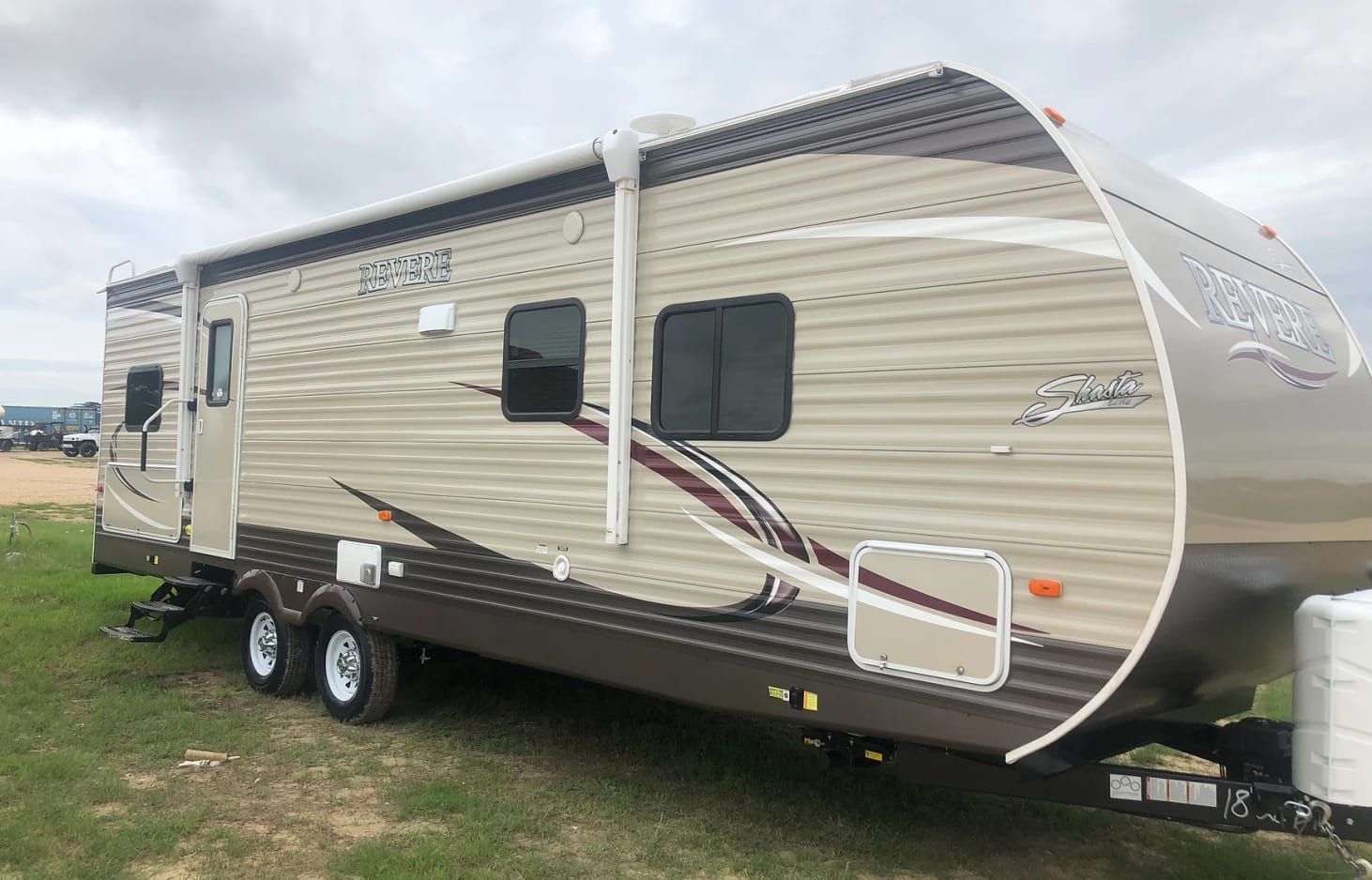 A travel trailer is parked in a grassy field.