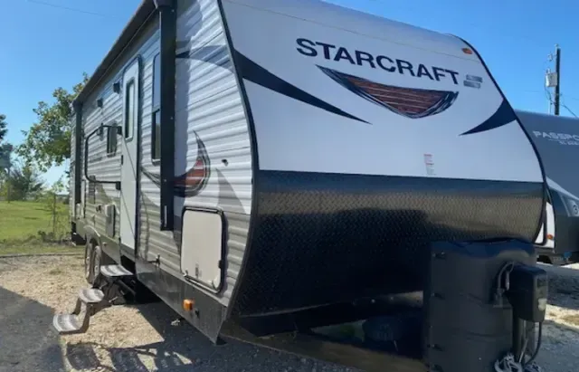 A starcraft trailer is parked on the side of the road.