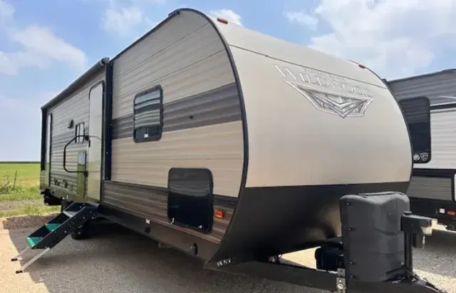 A travel trailer is parked on the side of the road.