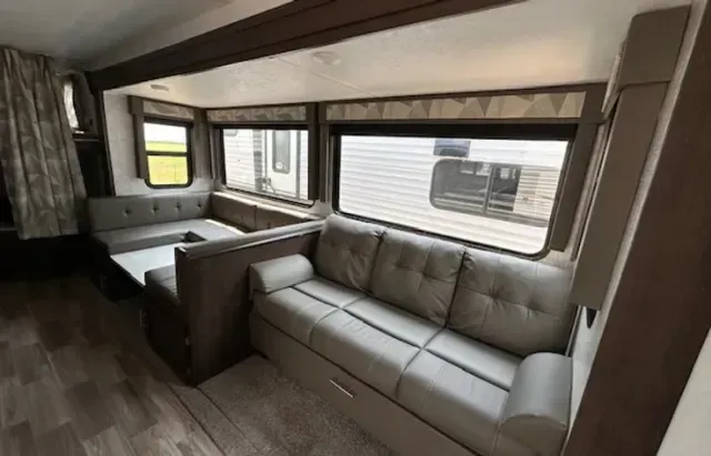 A living room with a couch and a table in a trailer.