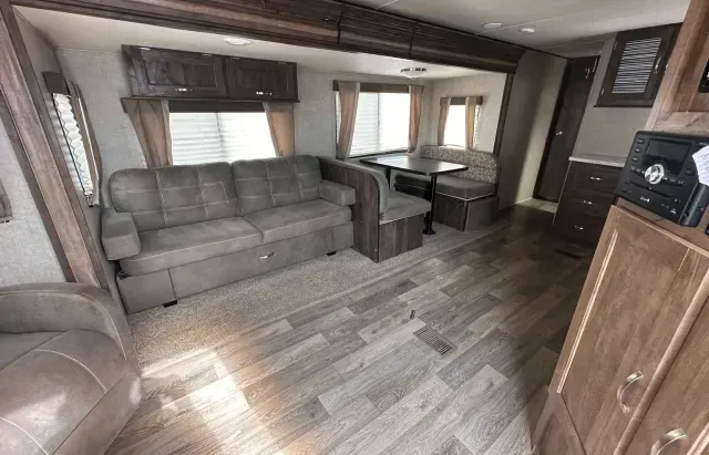A living room in a trailer with a couch and a table.