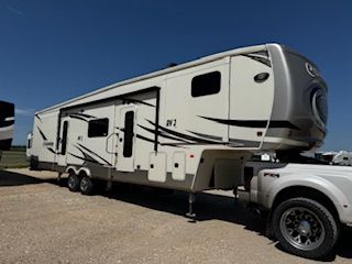 A white rv is parked next to a white truck.