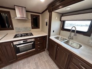A kitchen with a sink , stove , oven and microwave.