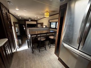 A kitchen with a table and chairs and a refrigerator.